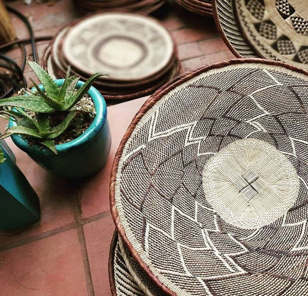 Batonga Handwoven trays on floor with plants
