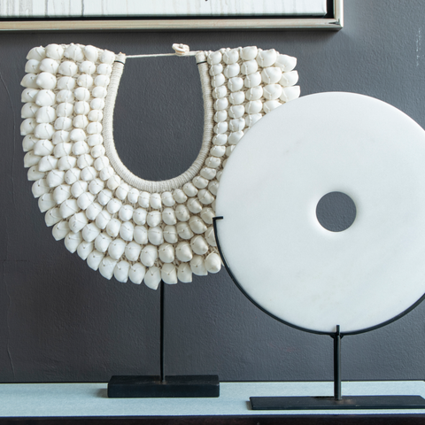 Shell necklace and orbi white marble disk on shagreen side table