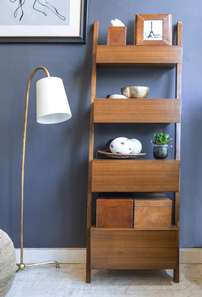Shikari leaning shelf against blue wall with floor lamp